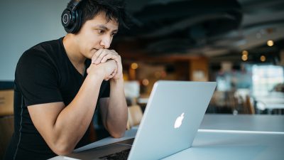 Man At Computer Watching Webinar or Live Stream Video